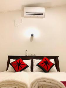 una camera da letto con un letto con cuscini rossi e neri di Waves a Hikkaduwa