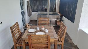 una mesa de madera con sillas y platos. en Karoo Vreugde, en Merweville