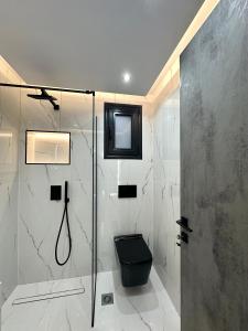 a bathroom with a shower with a black toilet at Golden Ecco Suites in Nafpaktos +34 photos