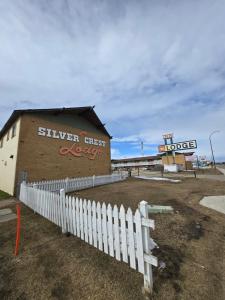 a building with a white fence in front of it at Silver crest lodge in Grande Prairie +5 photos