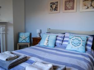 a bedroom with a bed with blue and white pillows at Seashells in Bridlington