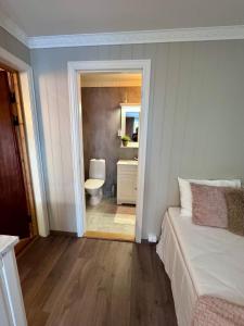 a bedroom with a bed and a bathroom with a toilet at Bispen Villa Utsikten in Åndalsnes +91 photos