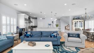 un soggiorno con divani blu e una cucina di Pet Friendly, Bayside Surf City, Private Yard, Pool, Elevator Roof Top Deck Beach Badges a Surf City