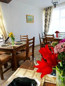 a dining room with a table with a red flower on it at Pensiunea Regina Deltei in Băltenii de Sus +33 photos