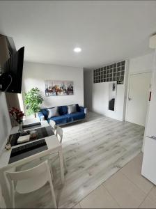 Una sala de estar con un sofá azul y una mesa. en EMPECINADO 4 Personas, en Alcalá de Henares