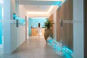 a woman in a white dress walking down a hallway at Hermitage Resort & Thermal Spa in Ischia Town +62 photos