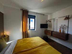 a bedroom with a yellow bed and a window at Golden Sunset 3 in Njivice