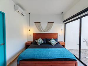 a bedroom with a large wooden bed with blue sheets at Blissful Homes in Huacas +37 photos
