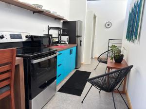 a kitchen with blue cabinets and a black stove at Blissful Homes in Huacas