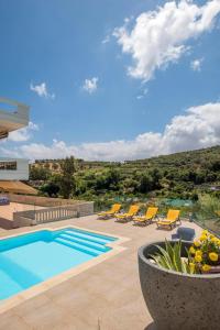 a swimming pool with lounge chairs and a pool at Lucia's Home in Stalos
