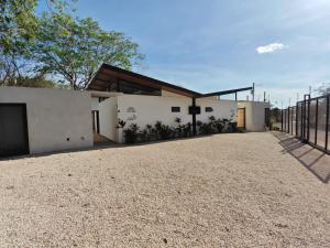 a white house with a fence and a gravel driveway at Blissful Homes in Huacas