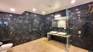 a bathroom with a black marble wall at Casa Pallazzo Luxury Villa - 10BHK Private Pool in Baga