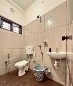 a bathroom with a toilet and a sink at Skye by livNstay in Trivandrum