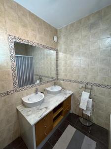 a bathroom with two sinks and a large mirror at Casa Esperança - carefree living with big private pool and great views in Olhão +28 photos