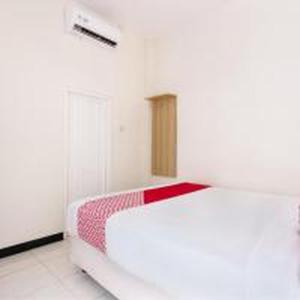 a bedroom with a white bed with a red blanket at Hotel O Cozy Residence Syariah in Malang +18 photos