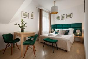 a bedroom with a bed and a table and chairs at APARTAMENTY VILLA PIGMALION - sauna, jacuzzi, parking, ogród in Kudowa-Zdrój +86 photos