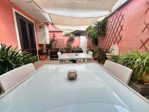 a patio with a table and chairs and plants at B&B Epos Acitrezza in Acitrezza