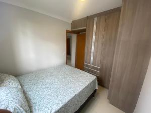 a bedroom with a bed and a wooden cabinet at Apartamento em frente ao novo shopping in Ribeirão Preto +31 photos