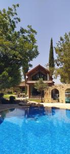 a large swimming pool in front of a house at Stone Garden Oasis Cottage in Limassol