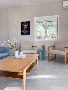 a living room with a wooden table and chairs at Casa De Vara in Nea Potidaea