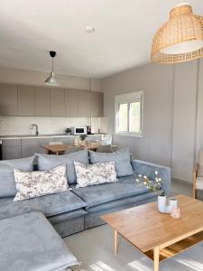 a living room with a blue couch and a table at Casa De Vara in Nea Potidaea