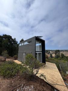 ein kleines schwarzes Haus auf einem Hügel in der Unterkunft Koru Ecolodge in Cáhuil