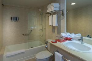 a bathroom with a sink and a toilet and a tub at Occidental Caribe - All Inclusive in Punta Cana