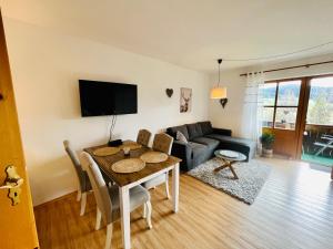 a living room with a table and a couch at Idyllische Ferienwohnung am Geiersberg in Hauzenberg