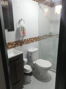 a white bathroom with a toilet and a sink at TAYLOR`S SWEET HOME in San Andrés