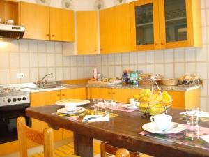 una cucina con tavolo in legno e ciotole di frutta di Cristina House a Bassano del Grappa