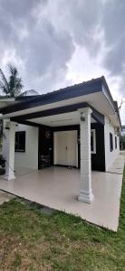a small white house with a blue roof at Laman Mesra Qaseh in Merlimau