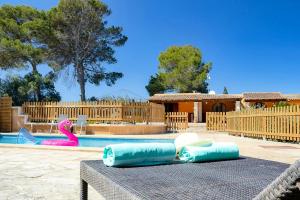 - une piscine avec des jets gonflables bleus sur une table en face d'une piscine dans l'établissement Son Peretó Petit, à Manacor