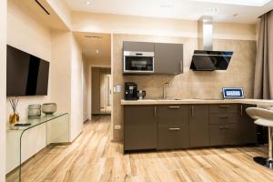 a kitchen with stainless steel appliances and wooden floors at Paci Luxury Suite in Rome