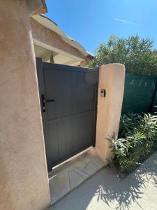 a black garage door in front of a house at Loucasa Location les Issambres in Les Issambres