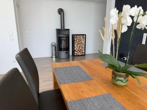 een eetkamer met een tafel en een open haard bij RhönLoft in Ostheim +17 foto's