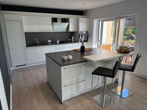 een keuken met witte kasten en een tafel en stoelen bij RhönLoft in Ostheim