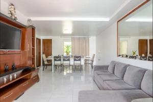 a living room with a couch and a dining room at Insta Serrambeach_house in Porto De Galinhas