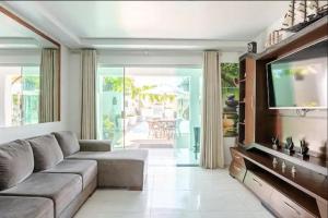 a living room with a couch and a television at Insta Serrambeach_house in Porto De Galinhas