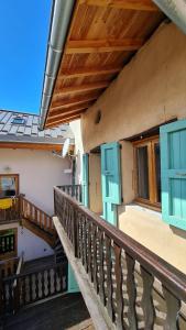 a balcony of a house with blue windows and a staircase at La Frisanfave, Maison de village, centre 65M2 in Abriès