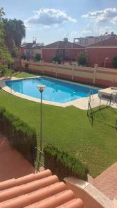 a swimming pool in the middle of a yard at Apartamento con piscina Bormujos in Bormujos