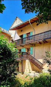 a building with a wooden staircase leading to a balcony at La Frisanfave, Maison de village, centre 65M2 in Abriès +36 photos