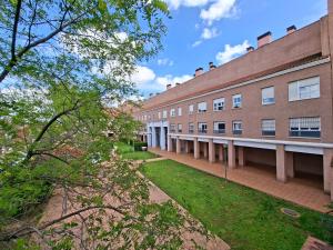 an exterior view of a brick building with grass at Apartamento con piscina Bormujos in Bormujos