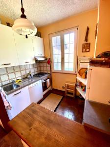 a kitchen with white cabinets and a wooden table at Villa Armonia Acero in Cerete