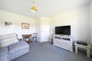 a living room with a couch and a flat screen tv at Spacious one bed apartment in a quiet leafy close. in Barnstaple