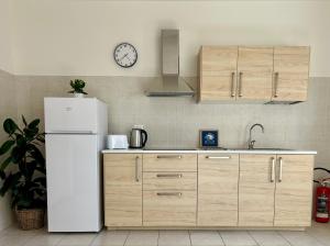 een keuken met een koelkast en een klok aan de muur bij Bellagio Wave Apartment in Bellagio