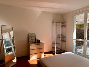 een slaapkamer met een bed, een ladekast en een spiegel bij Bellagio Wave Apartment in Bellagio +11 foto's