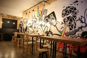 a room with tables and chairs and a wall with graffiti at Social Hostel Café e Bar in Curitiba