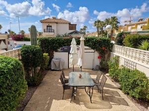 a patio with a table and chairs and umbrellas at Family Townhouse 6 sleeps Maribel in Ciudad Quesada
