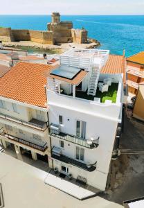 a white building with a view of the ocean at Il Vico del Greco B&B in Le Castella