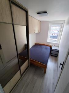 a small room with a bed and a window at Sweet Apartament 6 osobowy in Płock